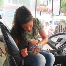 Girl counting money in the bus from Valenca to the ferry terminal to Morro de Sao Paulo